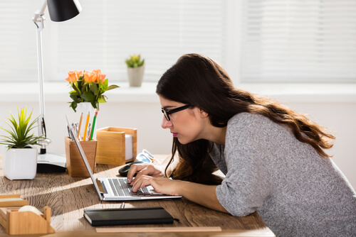 Businesswoman Sitting In Wrong Posture While Working On Laptop