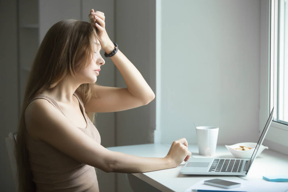 Young woman tired of sitting at laptop