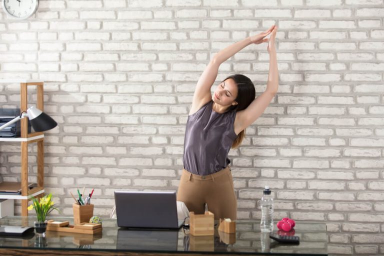 Young Businesswoman Stretching At Workplace In her modern Office