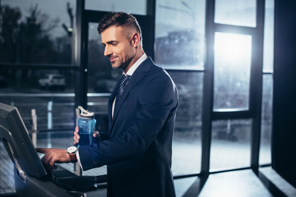  businessman in suit exercising on treadmill 