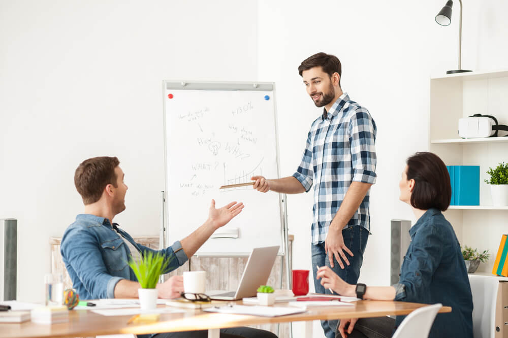 colleagues are discussing benefits of standing at work