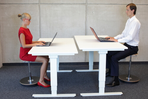 men and women working in correct sitting posture at sit-stand desks