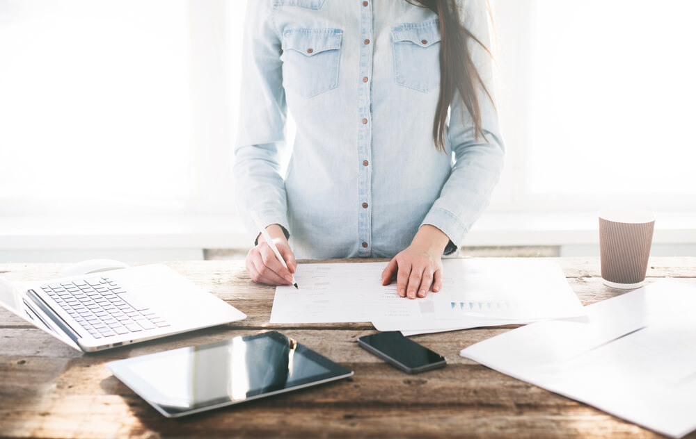  Woman is working at a wooden standing desk