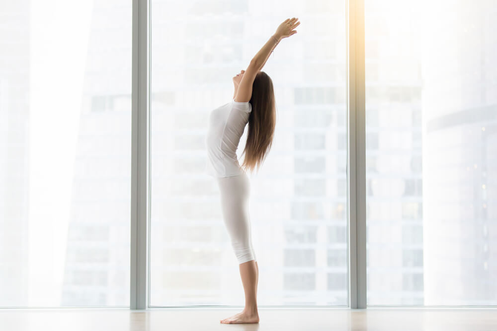 Young woman is standing in Tadasana - Mountain Pose