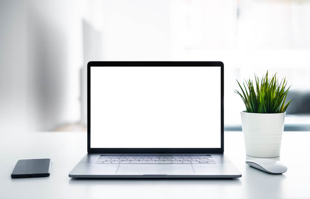 Laptop with blank screen on white table 