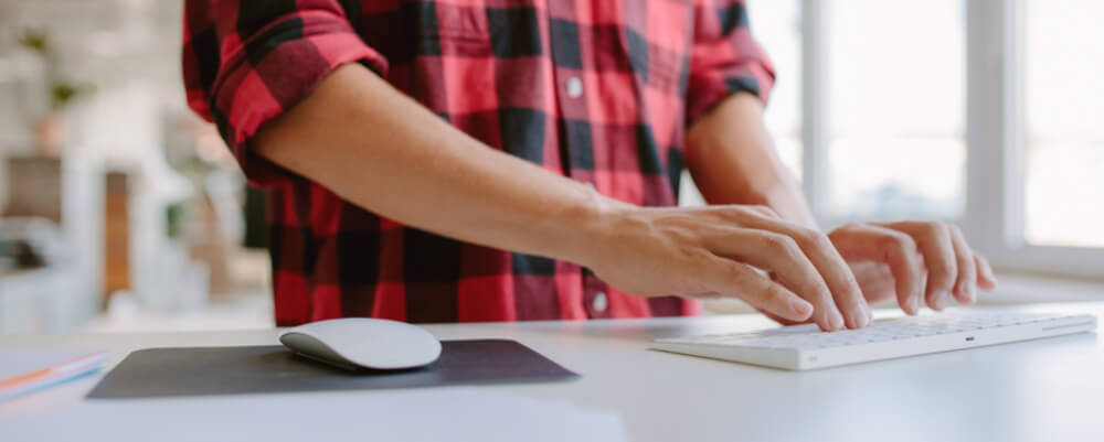 businessman working on computer while standing at his desk in the office